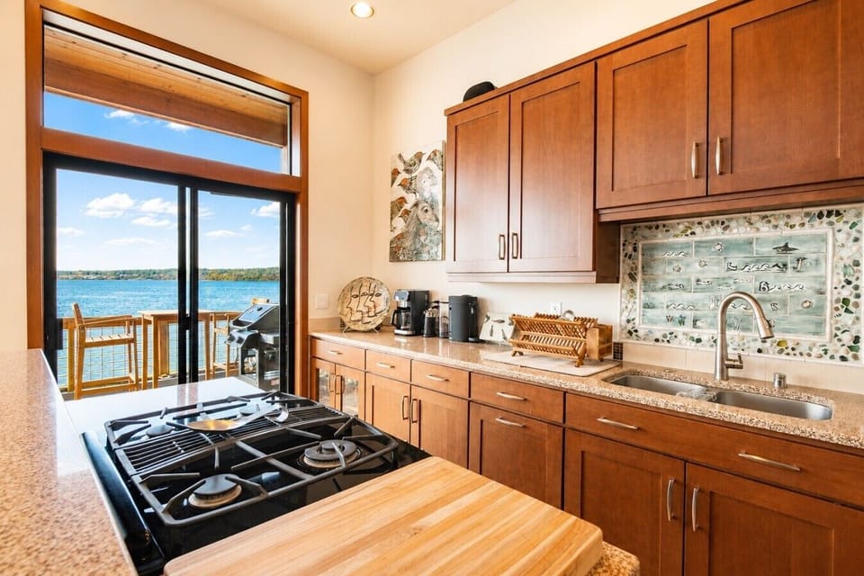 Stocked Chefs kitchen with stainless appliances and waterfront views