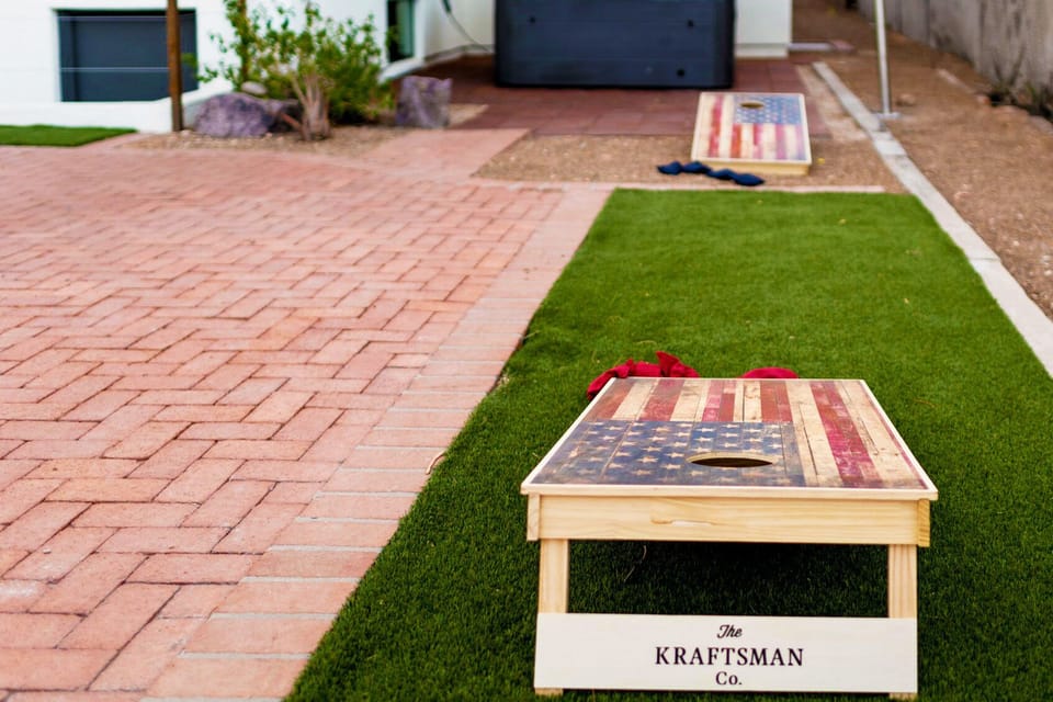 Outdoor space featuring a full-size cornhole set.