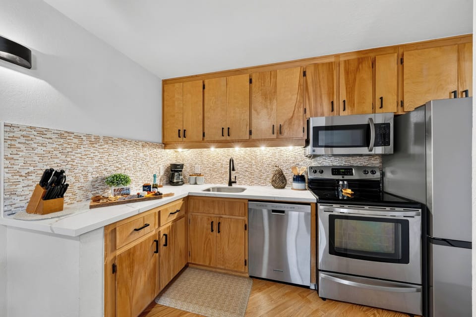 Compact kitchen with wood cabinetry, a coffee station, and counter space for easy snacks or breakfast prep.