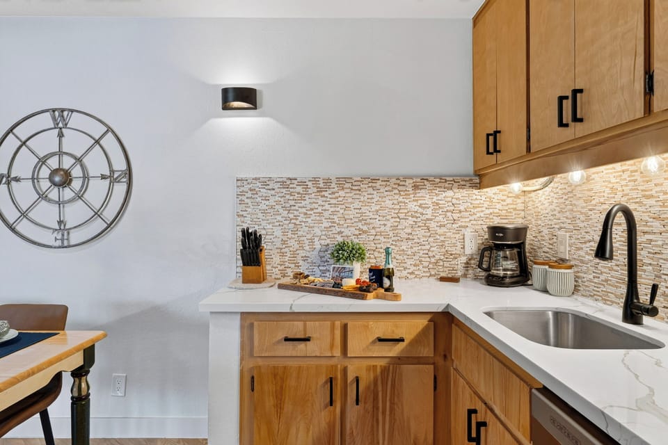 Compact kitchen with wood cabinetry, a coffee station, and counter space for easy snacks or breakfast prep.