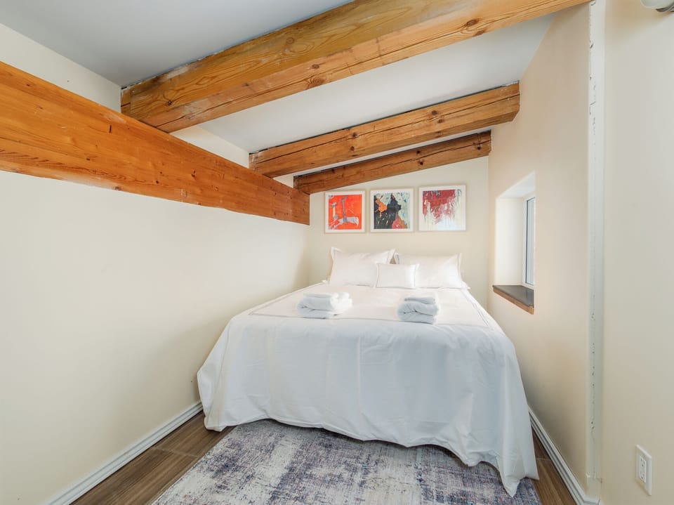 A cozy bedroom with exposed wood beams creates a peaceful retreat for a restful night's sleep.