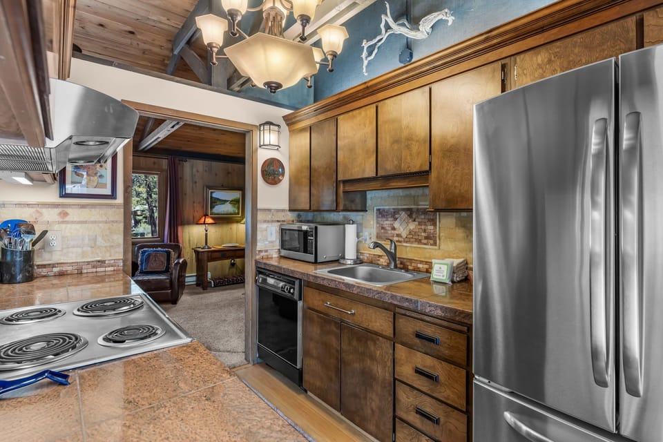 Your fully-equipped kitchen features stainless steel appliances, ample counter space, and warm wood cabinetry—ready for whipping up home-cooked meals or snacks during your mountain getaway.