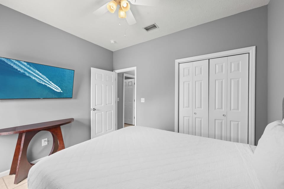 Relax in your peaceful bedroom with soft gray walls, vaulted ceiling, and calming coastal artwork. Ample closet space keeps your stay organized and comfortable.