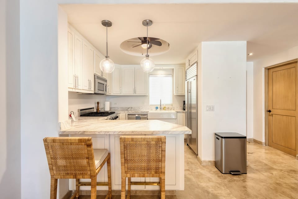 Your bright, modern kitchen features marble countertops, premium appliances, and pendant lighting. The island with seating creates a warm space for morning coffee or meal prep.