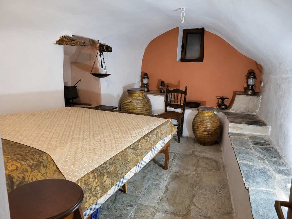 This rustic room is full of traditional character, with stone floors, curved white walls, and decorative pottery. A memorable space for guests who enjoy authentic local style.