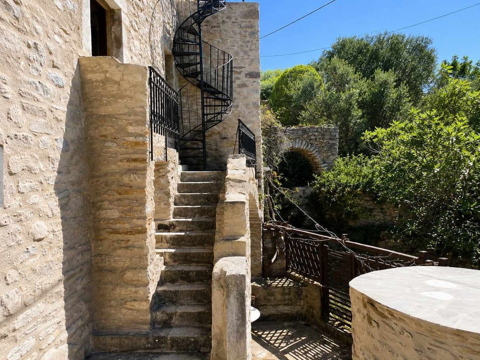 Stone steps lead through the traditional exterior of the property, surrounded by rustic walls and greenery