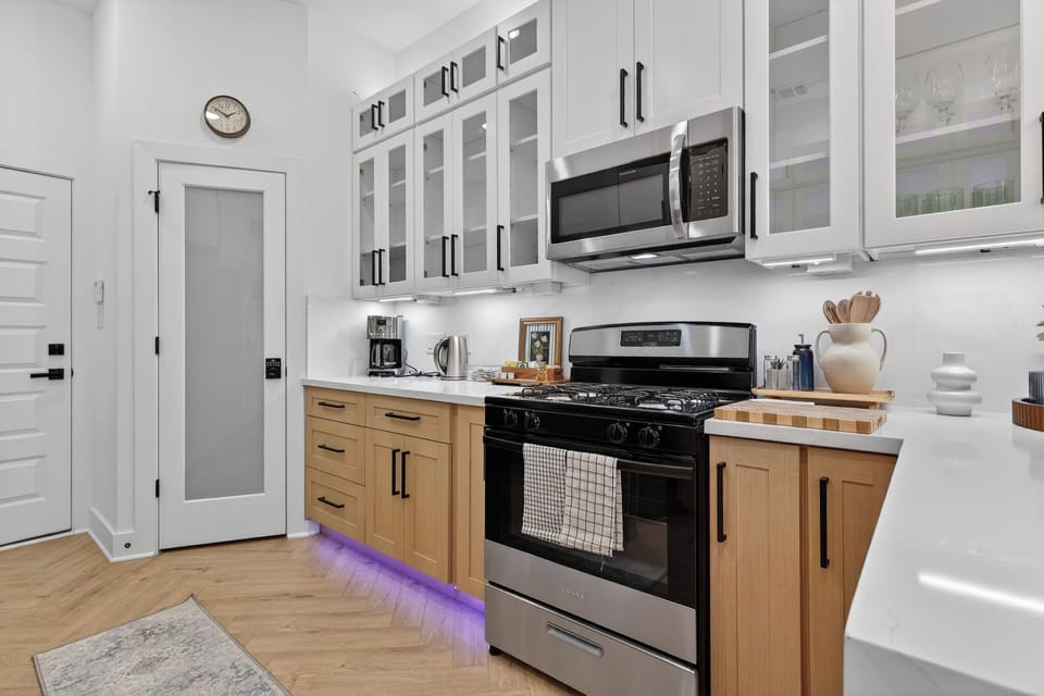 Sleek chef’s kitchen w/ gas range, quartz tops & coffee bar