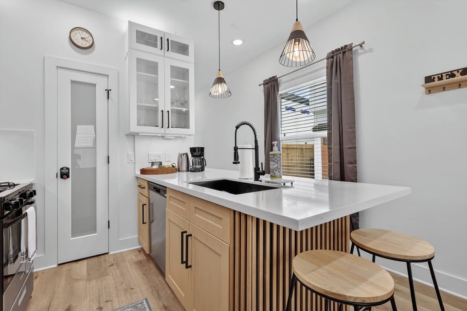 Modern kitchen with quartz peninsula, pendant lights, and coffee bar