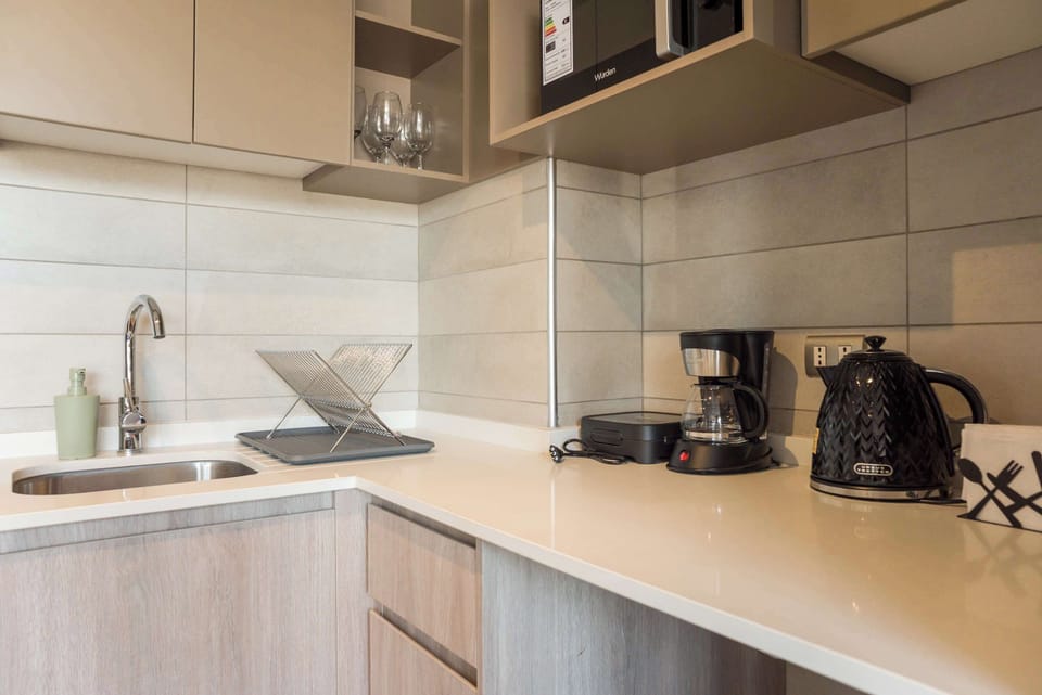 Sleek and modern kitchen equipped with essentials for your culinary needs, perfect for a cozy stay in the heart of the city.