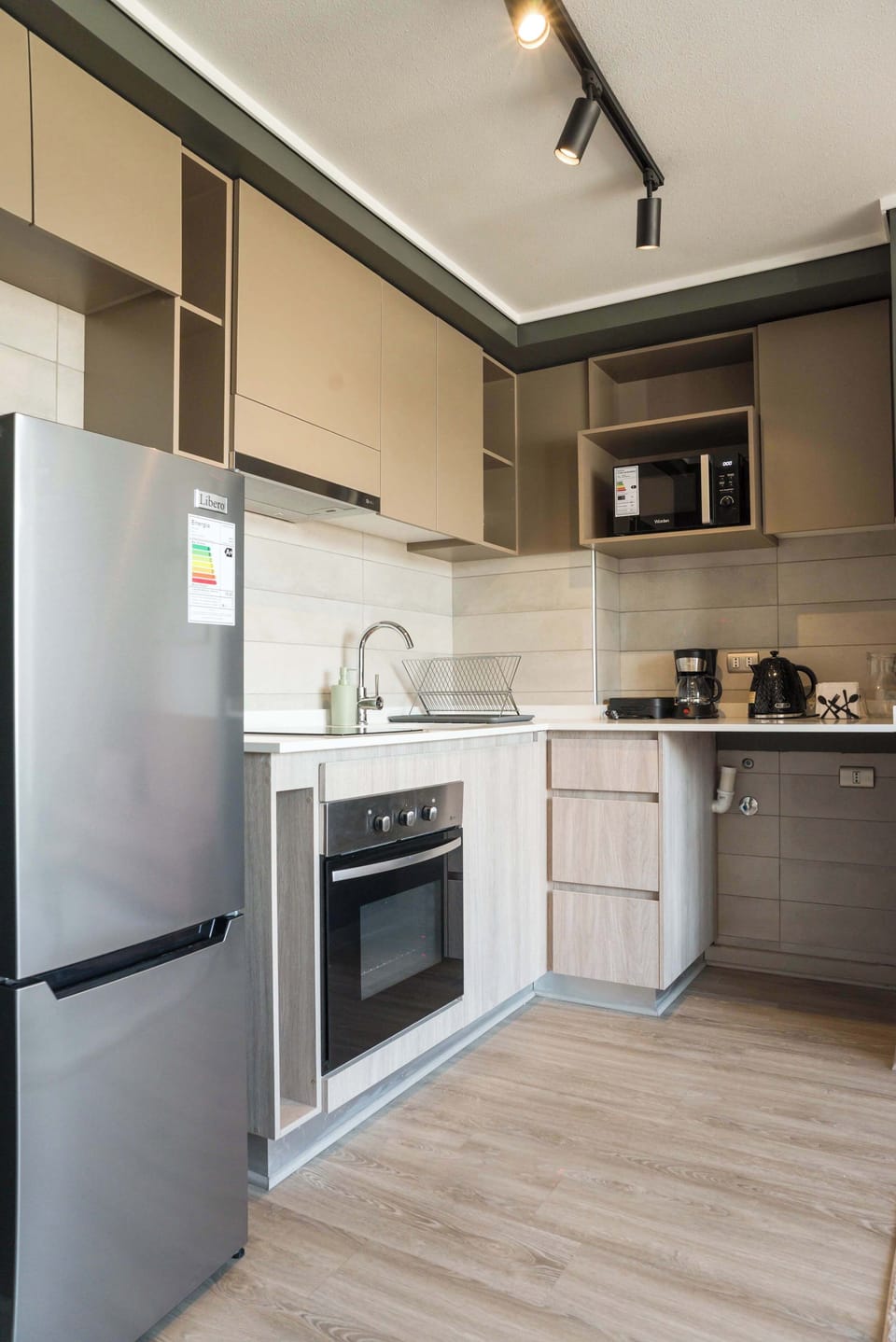 Sleek and modern kitchen equipped with all essentials for a comfortable stay. Perfect for cooking your favorite meals.