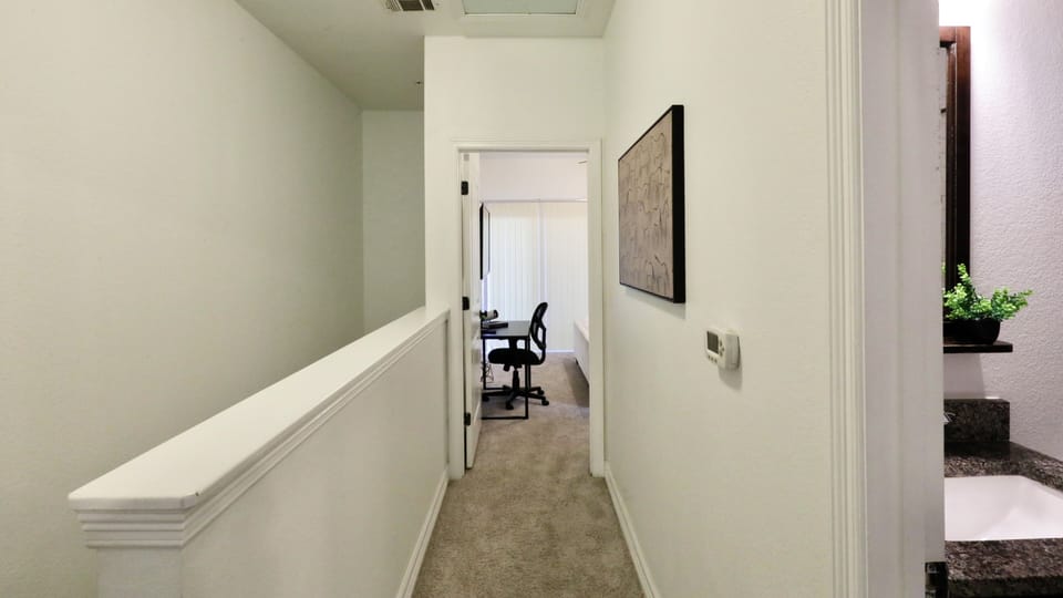 Bright upstairs hallway with dedicated workspace and easy bath access