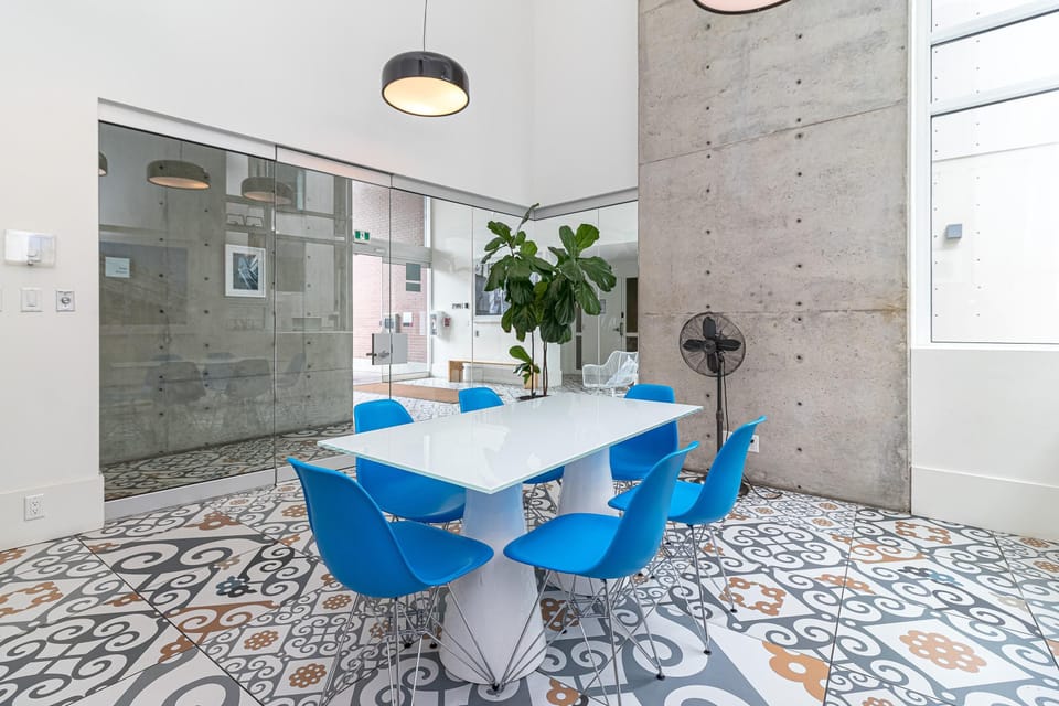 Gather with friends or neighbors in the bright community room, complete with a large dining table and colorful seating.