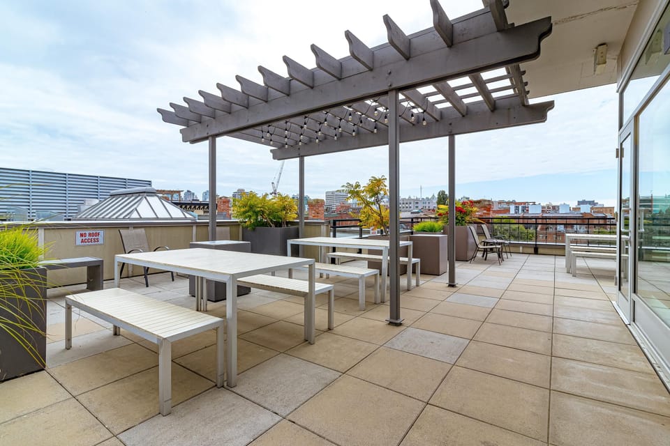 Step out onto the expansive shared rooftop patio, offering plenty of outdoor dining space for residents.
