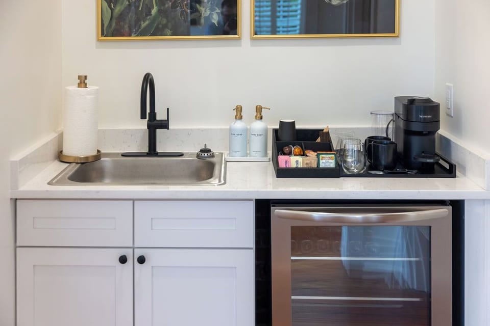 Modern kitchenette with coffee station, mini fridge, and sleek finishes