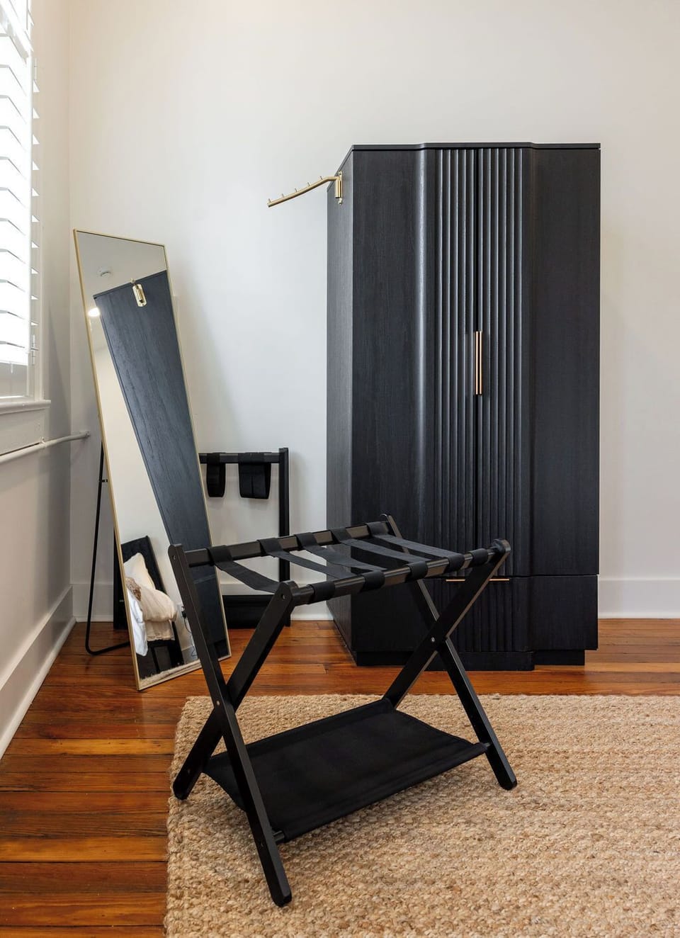 Modern wardrobe area with full-length mirror and convenient luggage rack