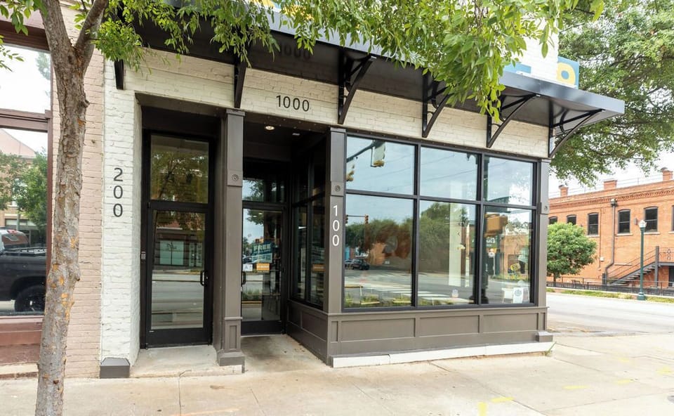 Bright corner storefront with large windows and inviting covered entry