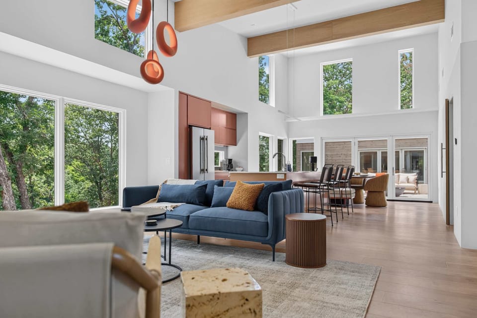 Soaring vaulted ceilings and walls of glass fill the open living room with natural light.