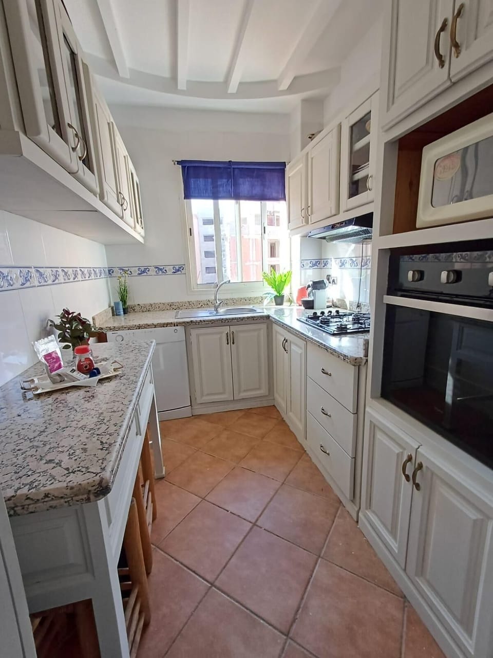 Fully equipped kitchen with oven, stovetop, dishwasher, and granite counters.