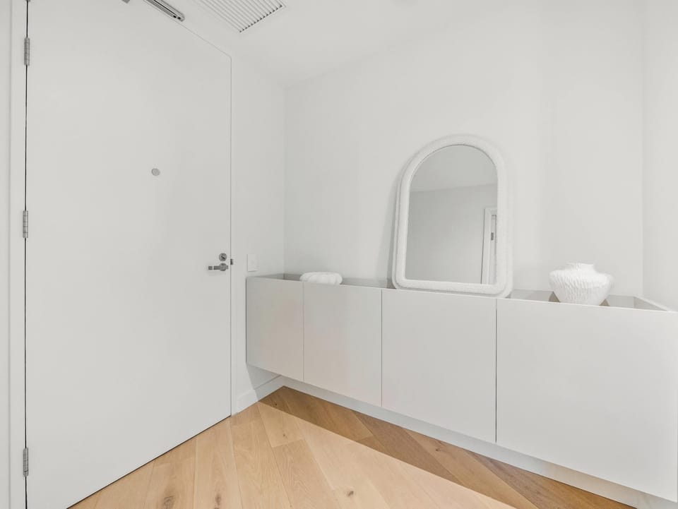 Entry, with a bench and an arched mirror to drop keys.
