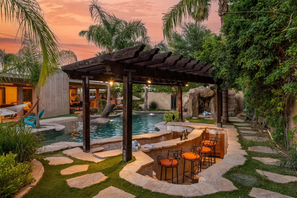 A lazy river, swim up bar, 2 grottos, waterslide, sandy beach, and hammock are a few of the many incredible outdoor amenities available at this beautiful home!