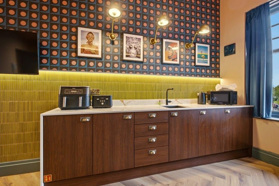 Lounge seating facing the kitchenette with patterned wall and artwork