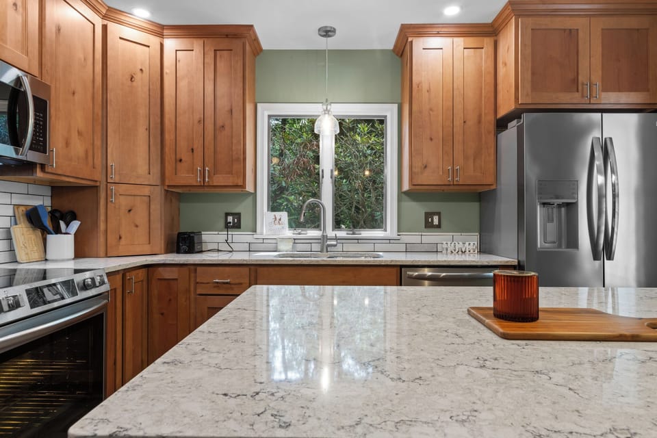 Bright gourmet kitchen with quartz island and stainless appliances