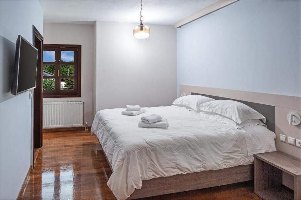 Spacious bedroom filled with natural light, offering a comfortable bed, modern furnishings, and a tranquil setting.
