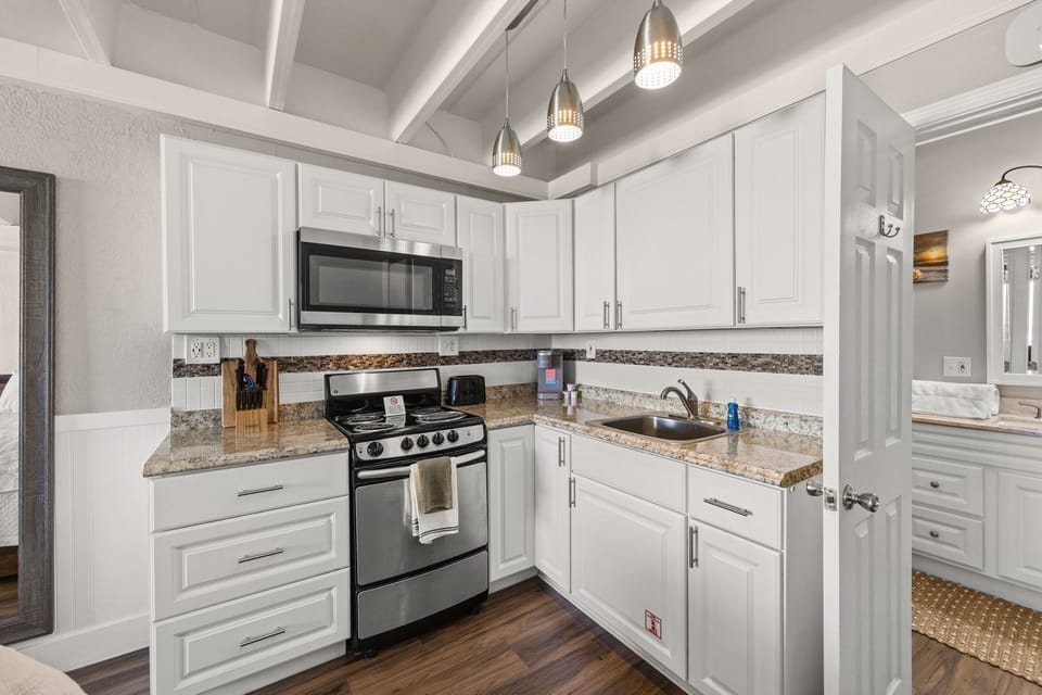 Step into your bright, fully-equipped kitchen featuring granite countertops, stainless steel appliances, and stylish pendant lighting. Prepare meals with ease and enjoy the modern, airy design.