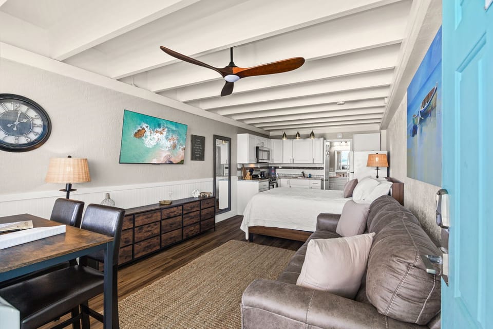 Step into your airy, open-plan retreat where coastal charm meets comfort. Relax on plush seating, enjoy meals at your dining table, and drift off in a cozy bed under a gentle ceiling fan—all within one inviting space.