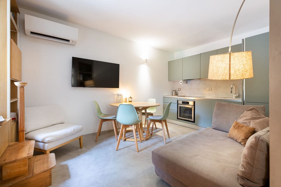 Open-plan living room with full kitchen, dining table and sofa