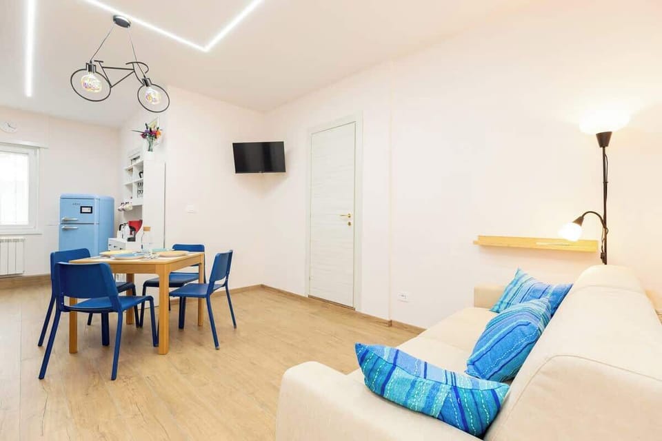 Il soggiorno: divano letto, tavolo da pranzo, TV e frigorifero retrò