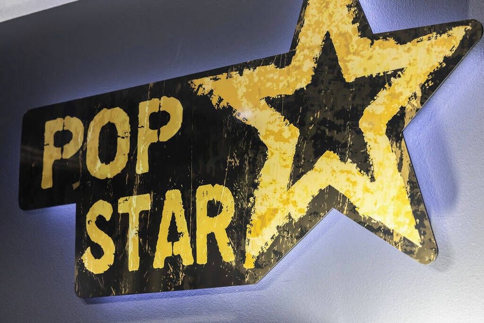 Experience a vibrant atmosphere with our striking "POP STAR" sign, where bold yellow letters pop against a dark backdrop. This playful design invites you to relax and enjoy your stay in style.