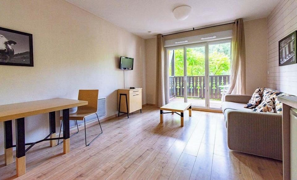 Sliding doors open the living area onto a balcony facing the pistes above Ax-les-Thermes, hiking trails in summer.