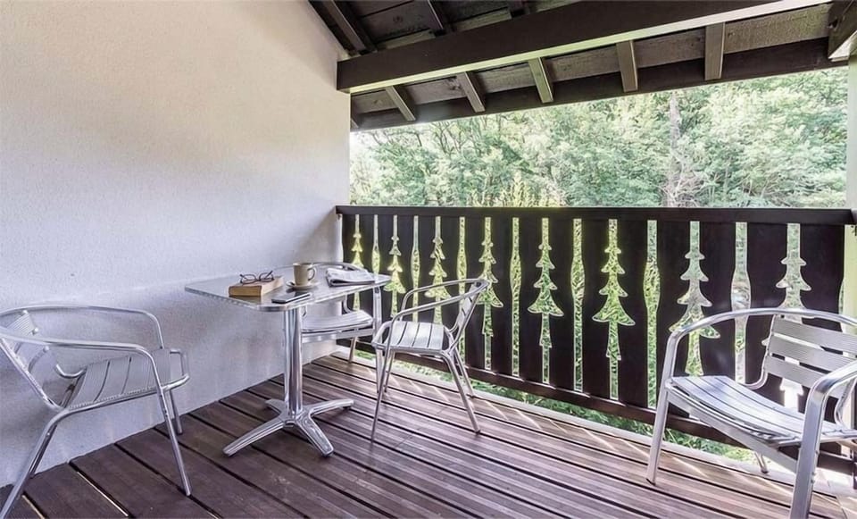 The balcony looks over greenery toward the peaks surrounding Ax-les-Thermes, year-round.