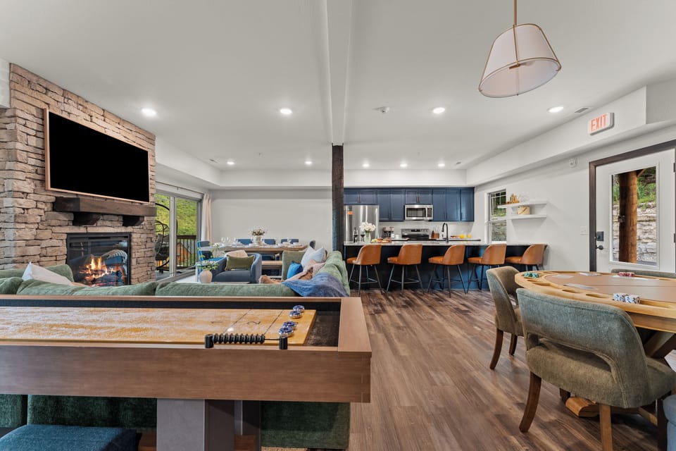 Play all day in the open-concept great room, with a full-size shuffleboard table, poker table, and stacked-stone gas fireplace.