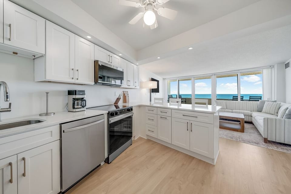 Cook in style in this beautifully updated kitchen featuring sleek white cabinetry and stainless steel appliances.