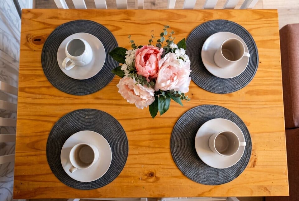 Dining table set for four with fresh flowers for shared meals