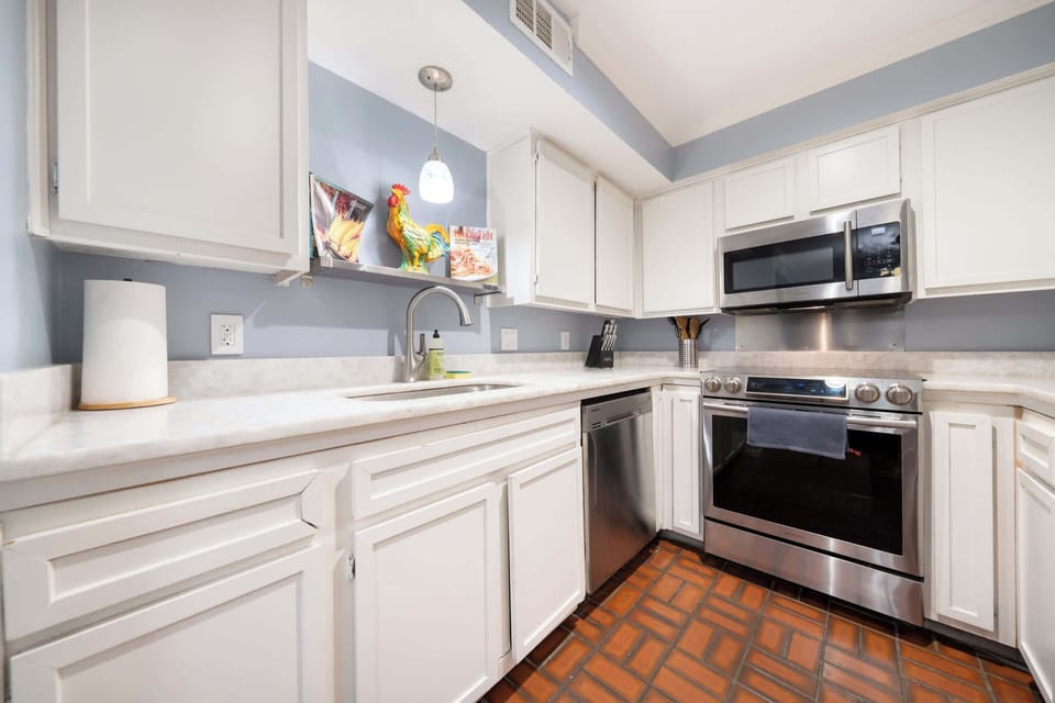 Modern kitchen with stainless steel appliances and charming decor, perfect for culinary adventures.