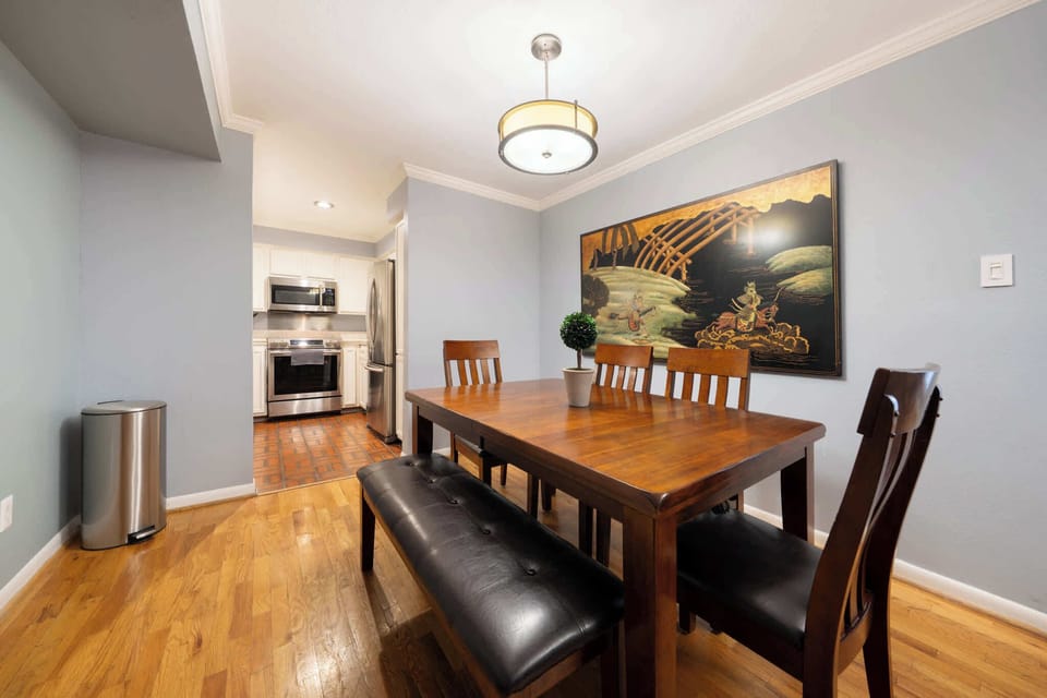 Spacious dining area with elegant wooden furniture and modern kitchen access, perfect for family meals.