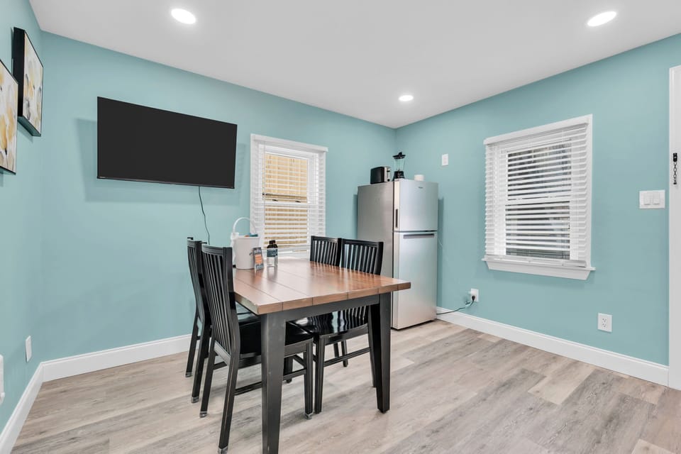 Bright dining nook with TV, coffee station, and full-size fridge