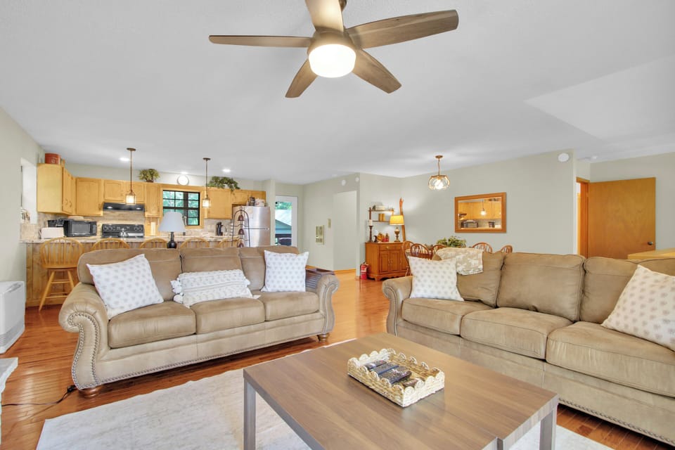 Gather in the bright, open living area, where plush seating, a welcoming dining space, and a full kitchen come together — the perfect hub for cooking, relaxing, and mountain togetherness.