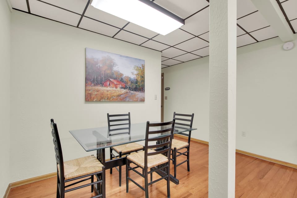Savor mountain meals at the bright dining area’s sleek glass table, seating four in style, all grounded by warm wood floors that add rustic charm to every shared meal and conversation.