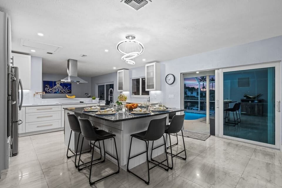 Modern chef’s kitchen with island seating and easy access to the pool