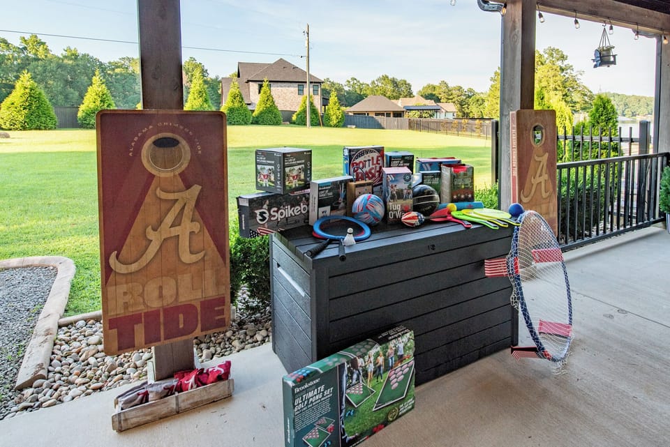 Covered patio with lawn games and a spacious backyard for outdoor fun