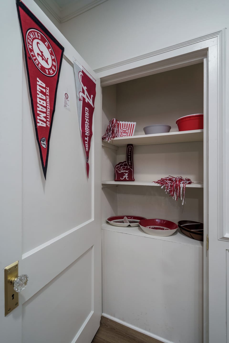 Crimson Tide-themed storage nook with extra servingware and game-day flair
