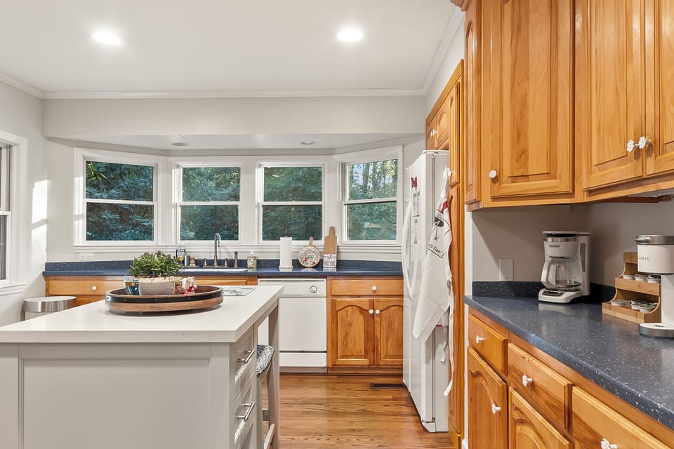 Bright kitchen with island, bay windows, and warm wood finishes