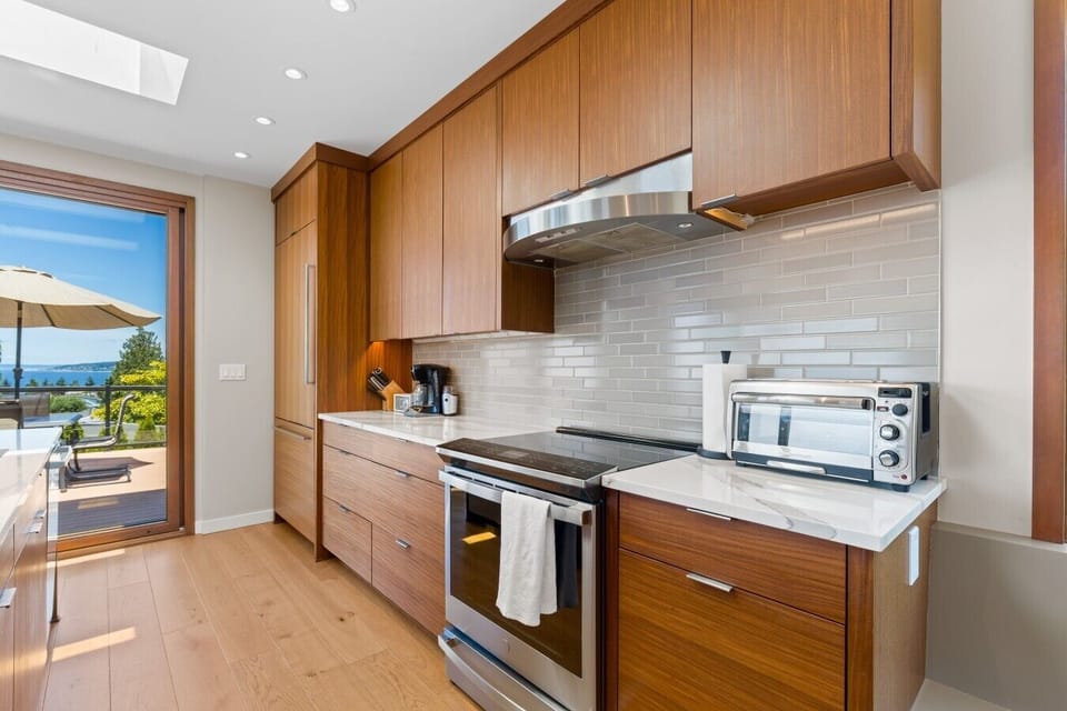 Sleek range and marble counters framed by an open patio view.