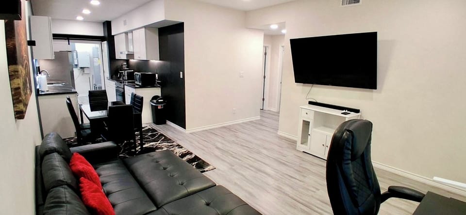 Living Room: Spacious with sofa bed, desk, 65” TV, blackout curtains.