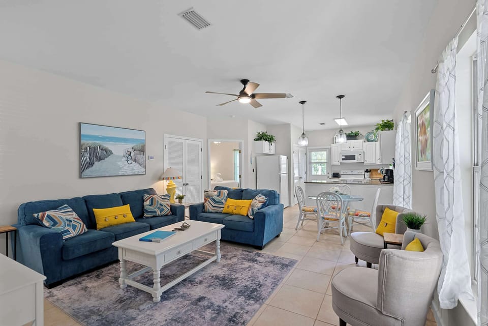 Bright, open living area with comfortable seating, dining space, and a fully equipped kitchen in this three-bedroom Orange Beach condo.