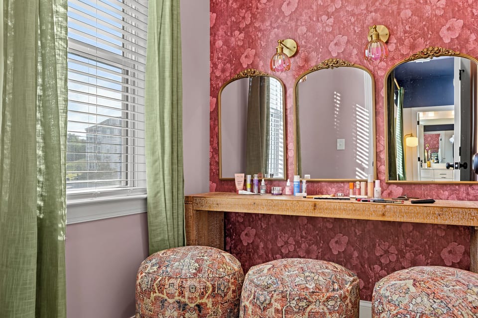 Glam vanity nook with triple mirrors, natural light, and chic seating